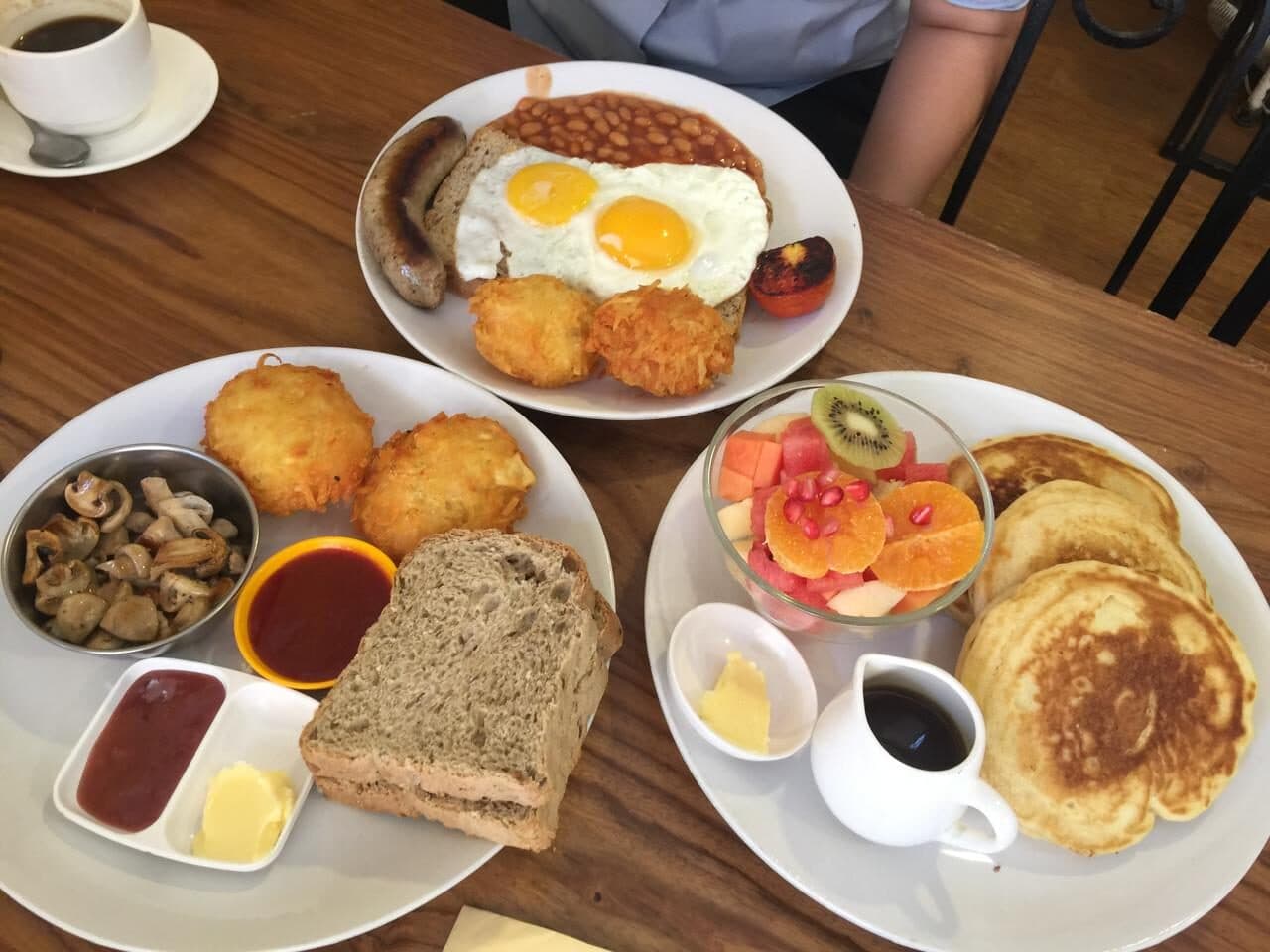 A full breakfast — fried eggs, sausage, beans, hash browns, mushrooms, toast, pancakes and fruit