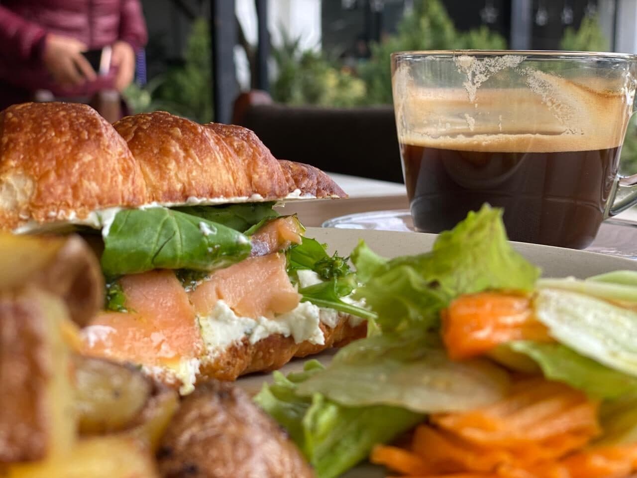 Smoked salmon croissant with salad and a black coffee