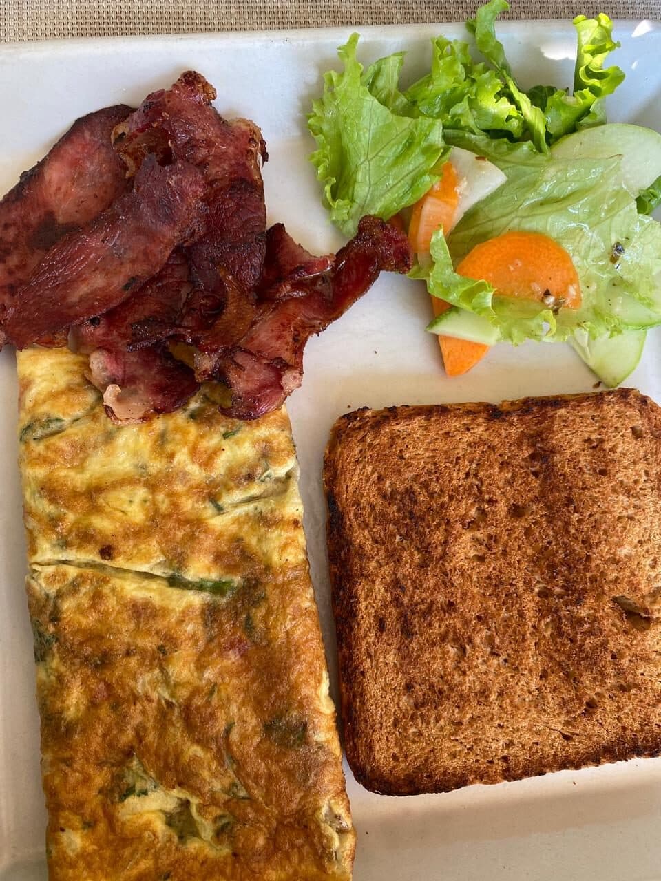 Herb omelette with crisp bacon, salad and toast