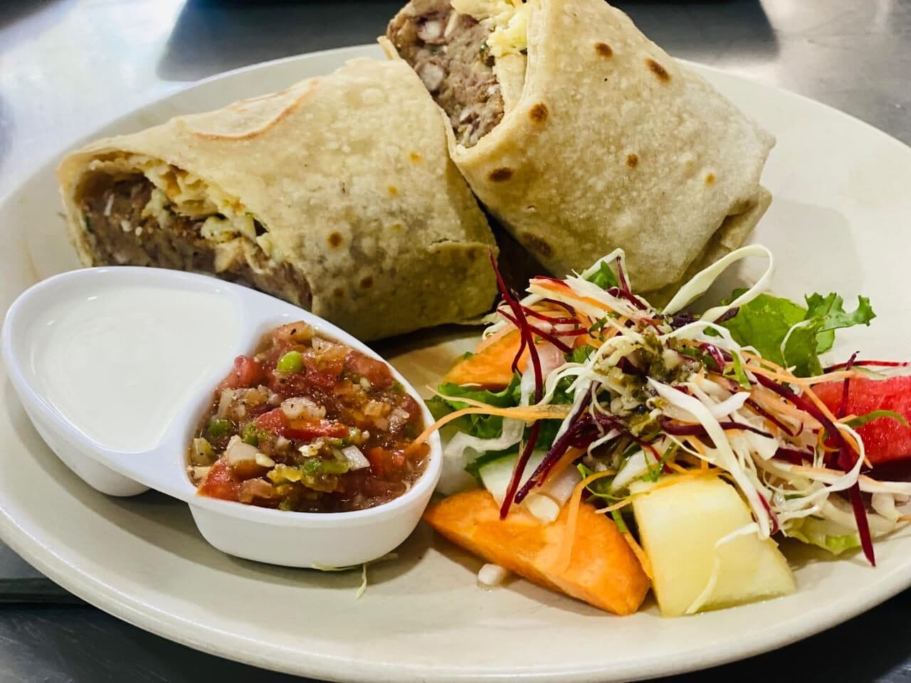 Burrito with salsa, sour cream and salad